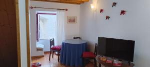 a living room with a table and a tv at A Casinha do Arco, Porta da Vila in Nisa