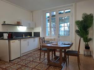 a kitchen with a wooden table and a dining room at Le Mosaïque, proche gare, terrasse, parking privé in Laval +20 photos