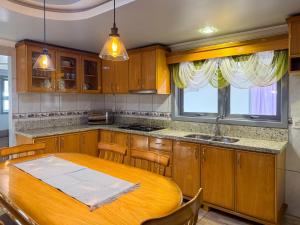 a kitchen with a wooden table and a dining room at Casa familiar até 10 pessoas com banheira in Gramado