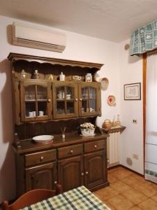 a kitchen with a large wooden cabinet in a room at Casa dei Nonni in Venturina Terme