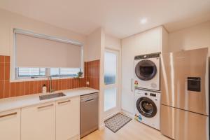 a kitchen with a refrigerator and a washer and dryer at The 2BR Hereford Haven - Relax Recharge Repeat in Christchurch