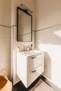 a bathroom with a white sink and a mirror at BHH Living Apartments - Zentrale Lage, ruhige Nächte, perfekter Komfort in Düsseldorf