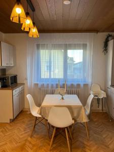 a kitchen with a table and chairs in a kitchen at Minimalist Cozy Apartment near Frankfurt in Altenstadt +21 photos
