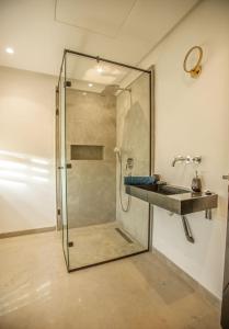 a glass shower stall with a sink in a bathroom at villa éden marrakech in Oulad Ikhia