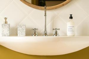 a white sink in a bathroom with a mirror at LE DOMAINE DE FERRAT in Mirambeau +70 photos