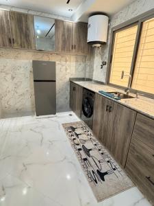 a kitchen with white marble flooring and wooden cabinets at Fes shore listings in Fès