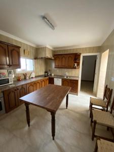 TebaにあるCasa Pepin y Paquitaの木製のテーブルと椅子のある広いキッチン
