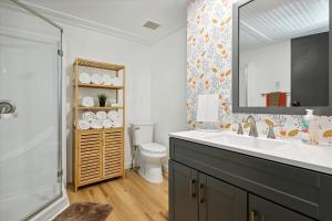 a bathroom with a sink and a toilet and a mirror at Sister Lakes Lakeside House - Sleeps 16 in Dowagiac +68 photos