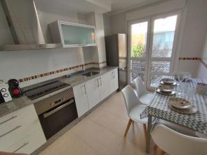a kitchen with a table and a dining room at Hollyfoz Arenal in Foz