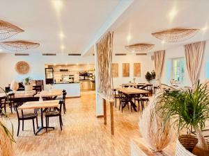 a restaurant with tables and chairs and a kitchen at Hôtel Domaine de la Sauge in Cudrefin