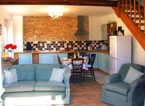 a living room with two couches and a kitchen at La Greletterie in Champagné-le-Sec