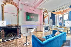 a living room with a blue couch and a fireplace at 07 chambre Bartown - La Villa ORA in Tourcoing