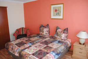 ein Schlafzimmer mit einem Bett mit orangefarbenen Wänden in der Unterkunft Südwindappartement in Zwenkau