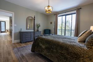 a bedroom with a bed and a dresser and a mirror at Algonquin Park,Sunset Paradise with Private Beach in Madawaska