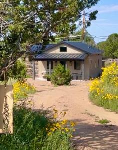 a house with a dirt road in front of it at CASA TUA SANTA FE - NM Farmhouse Sanctuary Soaking Room 1 acre private in Santa Fe