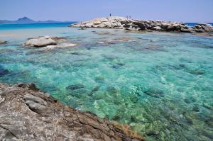 a beach with clear blue water and rocks at Costa Rei Panoramic Terrace- Free Parking- BBQ-Netflix in Costa Rei