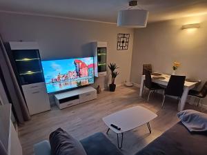 a living room with a couch and a tv and a table at Gdańsk - Quiet area with a sea view in Gdańsk +44 photos