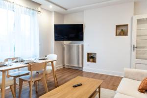 una sala de estar con una mesa y un sofá en BEL AMI 03 Strasbourg, en Schiltigheim