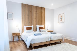 Un dormitorio con una cama grande con sábanas blancas. en BEL AMI 03 Strasbourg, en Schiltigheim