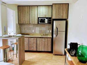 een keuken met houten kasten en een koelkast bij Define Pinheiros 34 in Sao Paulo +8 foto's