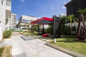 een paviljoen met een rood dak in een park bij Define Pinheiros 34 in Sao Paulo