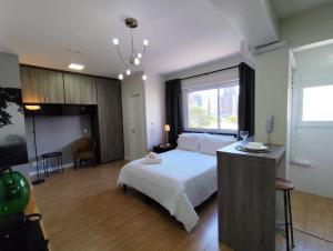 een slaapkamer met een wit bed en een groot raam bij Define Pinheiros 34 in Sao Paulo