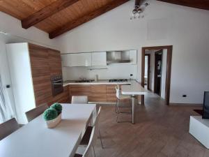 a kitchen with white counters and a table in a room at A casa dei miei in Celano