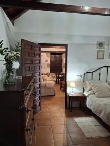 a bedroom with a bed and a living room at Casa Rural Tintilla in Vega de San Mateo