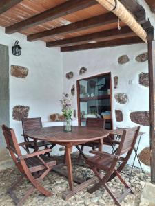 a wooden table and chairs on a patio at Casa Rural Tintilla in Vega de San Mateo