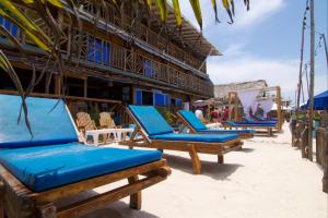 a row of blue lounge chairs on the beach at Cabaña Coral Azul in Playa Blanca
