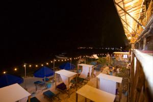 a group of tables and umbrellas on a beach at night at Cabaña Coral Azul in Playa Blanca +51 photos