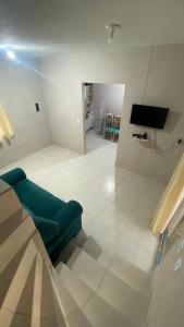 un soggiorno con un divano verde e una televisione di Casa Azul do Capão a Palmeiras