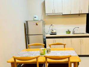 a kitchen with a table and two chairs and a refrigerator at Wand Apartment in Mactan Cebu International