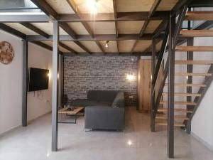 a living room with a couch and a staircase at Bakery apartments in Perea