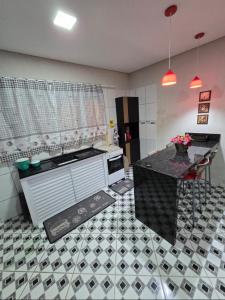 Una cocina con suelo de baldosas blancas y negras. en Casa aconchegante em Ubatuba, en Ubatuba