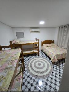 Habitación con 3 literas y alfombra. en Casa aconchegante em Ubatuba, en Ubatuba
