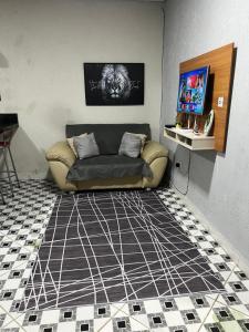 sala de estar con sofá en el suelo de baldosa en Casa aconchegante em Ubatuba, en Ubatuba 3 fotos más