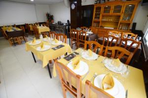 comedor con mesas amarillas y sillas de madera en Hostal Los Maños, en Blanes