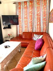 a brown leather couch with pillows in a living room at Jaco Hideaway Oasis in Jacó +38 photos