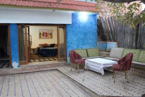 a patio with a couch and chairs and a table at Gîte rural à Jnane Imass in Jnane Imes