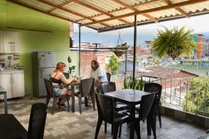 Due donne sedute ai tavoli su un patio con vista di Hotel Casa Verde Guatapé a Guatapé