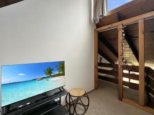 a living room with a flat screen tv and a window at 'Broulee Break' -2-Bed Beach House with Games Room in Broulee +15 photos