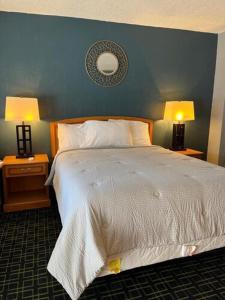 a bedroom with a large bed with two lamps on tables at American Inn Sacramento Downtown in Sacramento