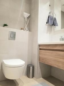 a white bathroom with a toilet and a sink at Beograd na vodi - Belgrade Waterfront Iris Apartment in Belgrade