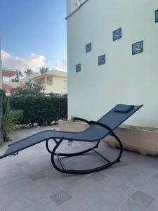 eine Bank auf einer Terrasse neben einem Gebäude in der Unterkunft EL ESCONDITE Bahía de Vera Naturista in Playas de Vera