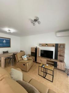 ein Wohnzimmer mit Sofa und Fernseher in der Unterkunft EL ESCONDITE Bahía de Vera Naturista in Playas de Vera