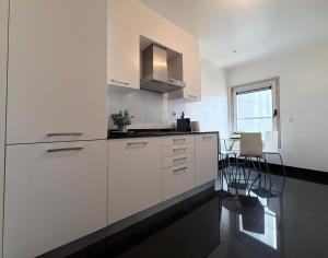 a kitchen with white cabinets and a table and chairs at Expo Luxury apartment in Lisbon