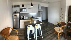 a kitchen with a table and chairs and a refrigerator at apto nuevo frente al mar in Piriápolis
