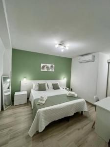 a bedroom with a large bed and a green wall at Casa Vacanze Arcobaleno in Gasponi