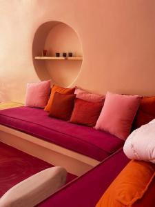 a couch with colorful pillows on it in a room at Maria Paradeiso Resorts in Imerovigli
